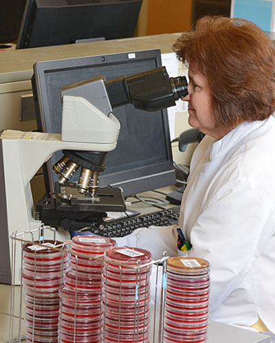 technician looking through microscope