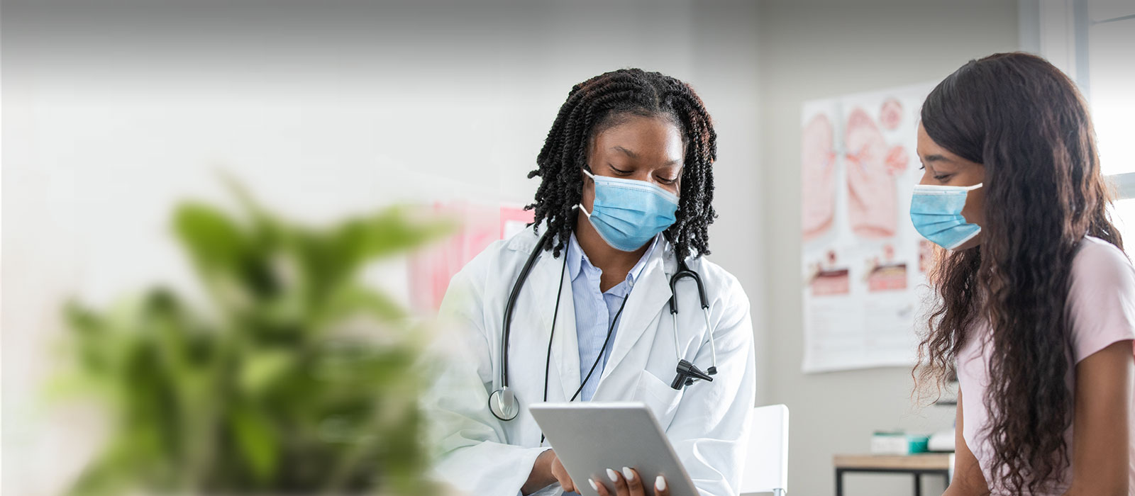 masked black female doctor and diverse patient