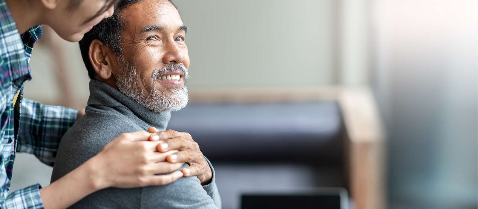 middle age man with comforting caregiver hand on shoulder