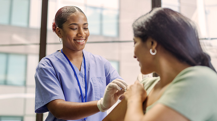 Diverse female nurse preparing for flu vaccination