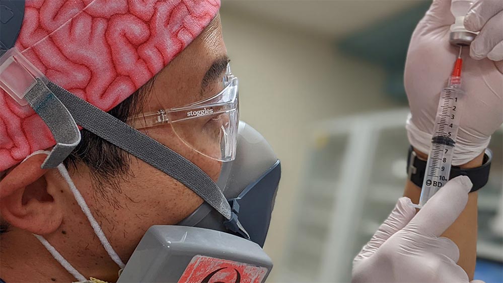 doctor in surgical gear with a syringe