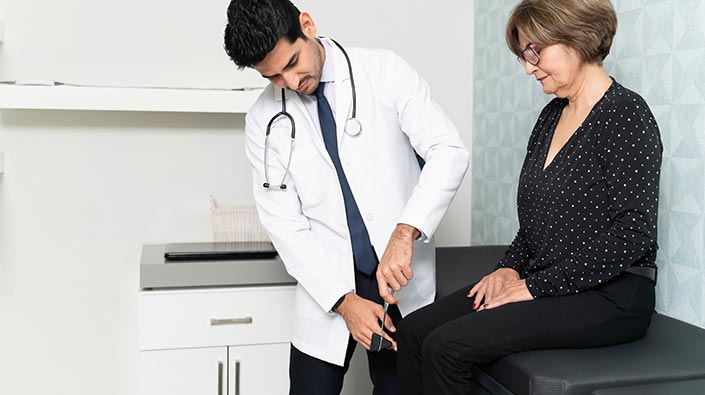 Doctor examining mature female patient