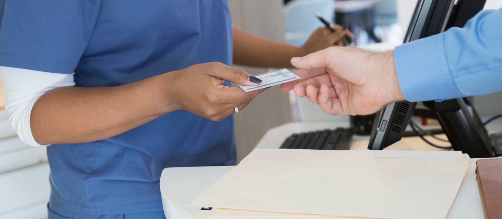 Patient providing ID card at medical office.