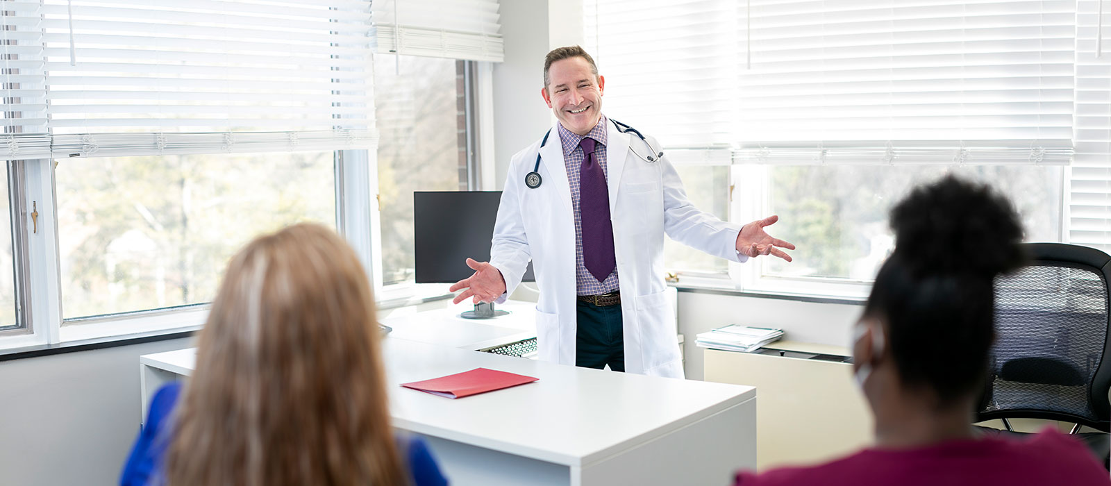 Happy doctor greeting patients