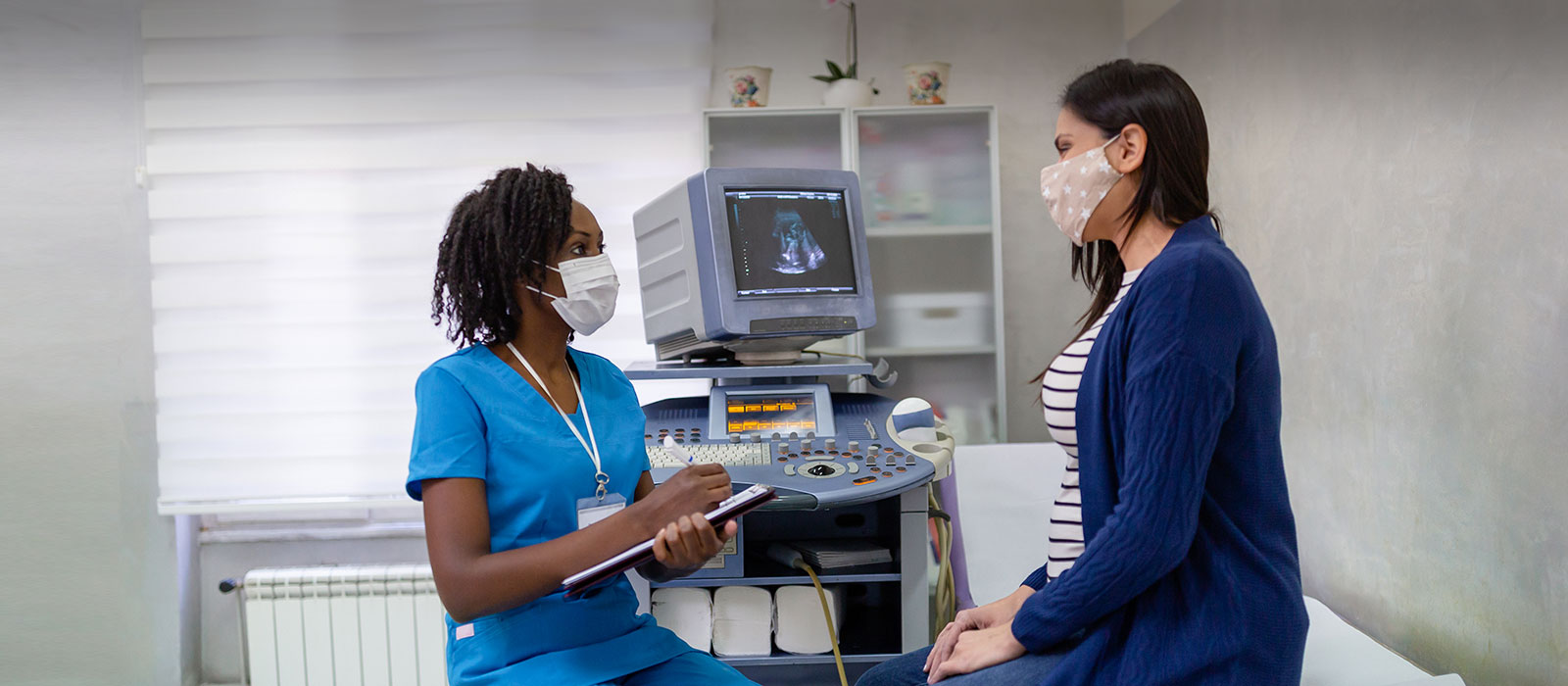 Black nurse consulting female patient