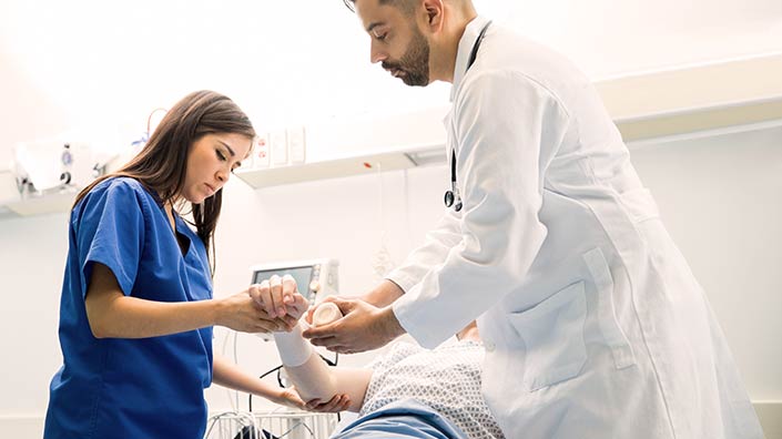 Medical team applying bandages to patient's arm