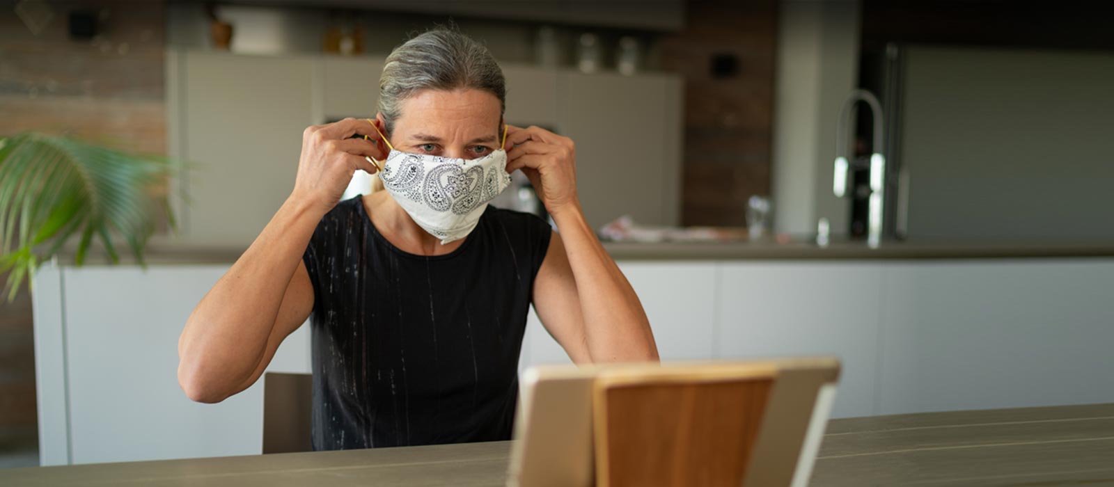 Mature woman putting on homemade mask