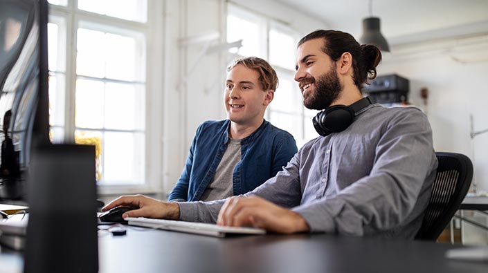 Young intern reviewing pc with mentor