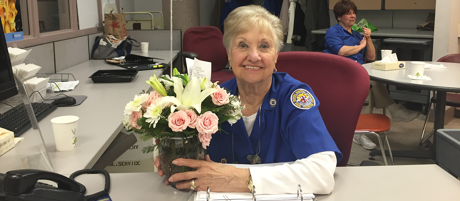 lady at desk holding flowers